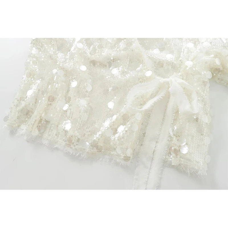 Close-up of a white lace fabric with a subtle pattern on a white background