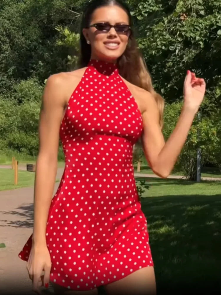 Woman wearing a red polka dot dress in an outdoor setting